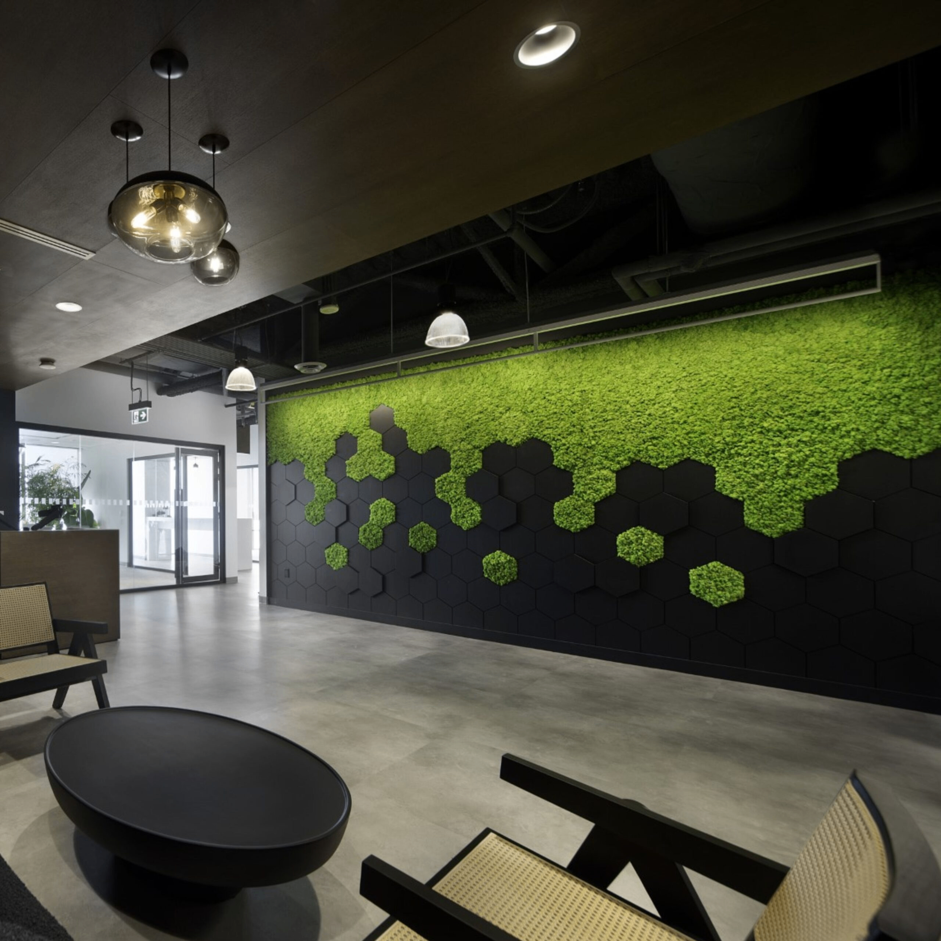 Continuous preserved moss acoustic wall installation in a modern lounge workspace